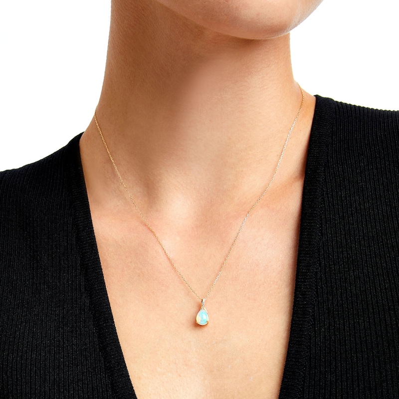 Pear-Shaped Opal and 1/20 CT. T.W. Diamond Ribbon Pendant in 10K Gold