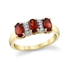 Thumbnail Image 1 of Oval Garnet and 1/20 CT. T.W. Diamond Three Stone Ring in 10K Gold